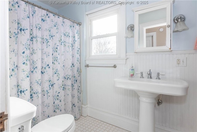 bathroom featuring a shower with shower curtain and toilet