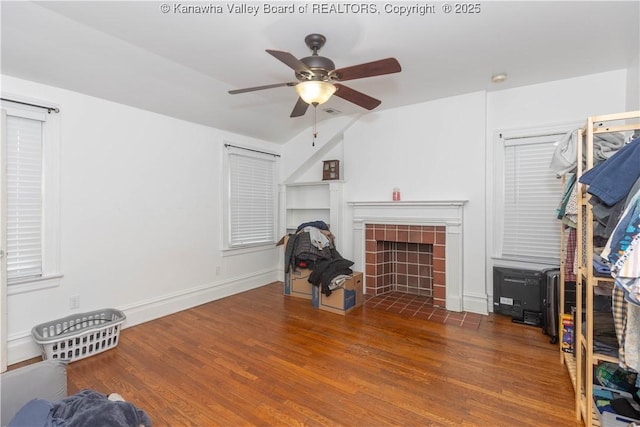 living room with a brick fireplace, dark hardwood / wood-style floors, lofted ceiling, and ceiling fan