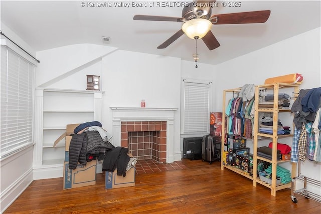 spacious closet with a tile fireplace and dark hardwood / wood-style flooring