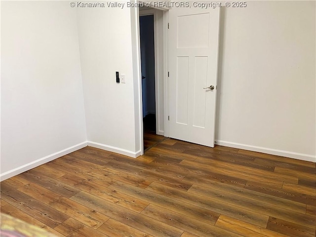 unfurnished room with dark wood-type flooring