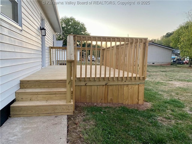 deck at dusk featuring a yard