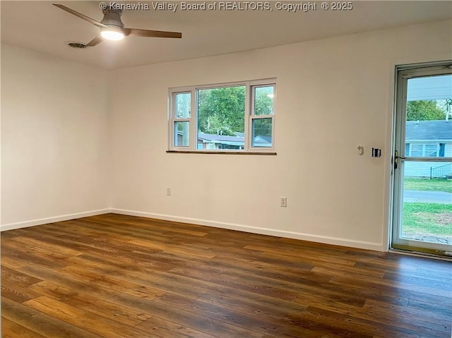 empty room with ceiling fan and dark hardwood / wood-style flooring