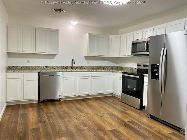 kitchen featuring white cabinetry, stainless steel appliances, sink, and light stone counters