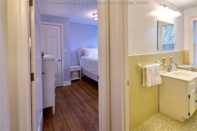 bathroom with vanity, wood-type flooring, and tile walls