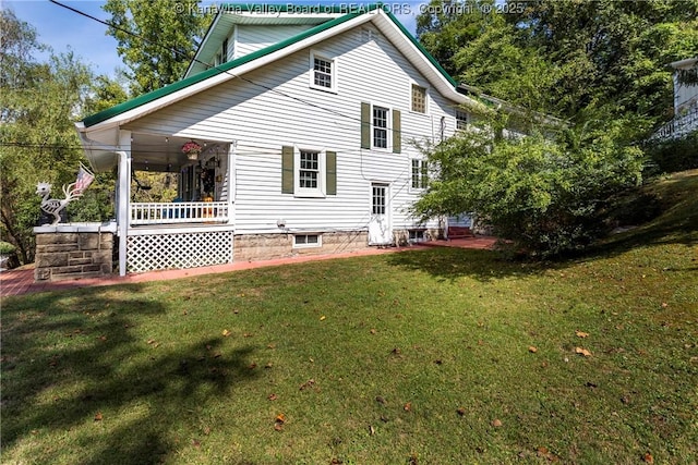 rear view of property with a porch and a yard