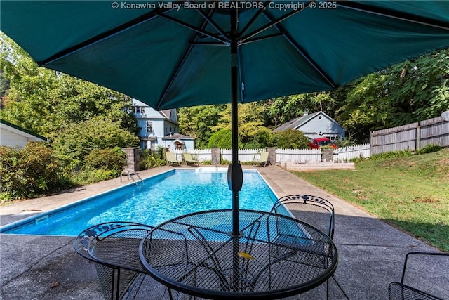 view of swimming pool featuring a lawn and a patio