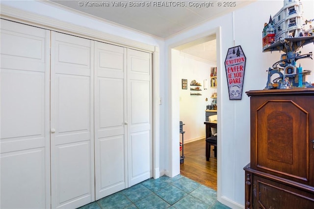 bedroom with light tile patterned flooring, ornamental molding, and a closet