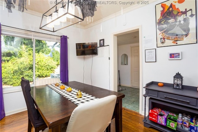 dining area with hardwood / wood-style floors, plenty of natural light, and ornamental molding