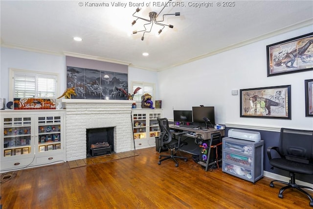 office with hardwood / wood-style flooring, crown molding, and a brick fireplace