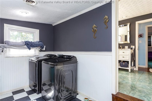 laundry area with a textured ceiling and washing machine and clothes dryer