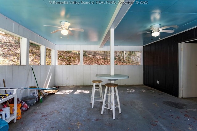 unfurnished sunroom with ceiling fan