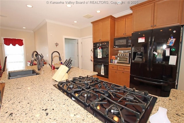 kitchen featuring sink, a kitchen breakfast bar, light stone counters, ornamental molding, and black appliances