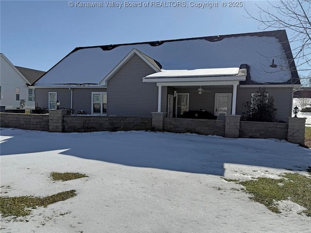 snow covered house featuring ceiling fan