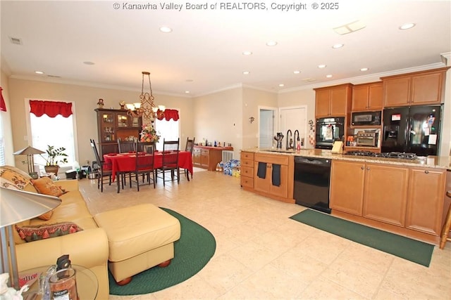 kitchen with decorative light fixtures, a wealth of natural light, light stone counters, and black appliances