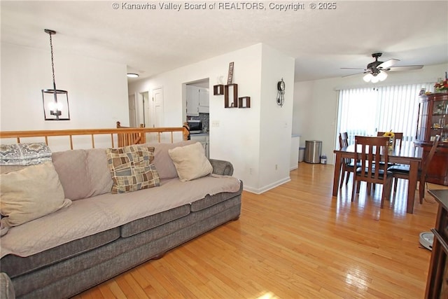 living room featuring ceiling fan and light hardwood / wood-style flooring