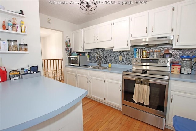 kitchen with sink, appliances with stainless steel finishes, white cabinetry, tasteful backsplash, and light wood-type flooring