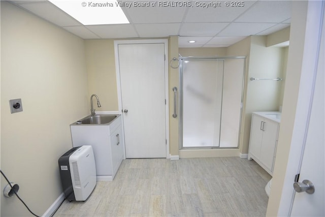 bathroom with hardwood / wood-style flooring, a paneled ceiling, vanity, and a shower with door