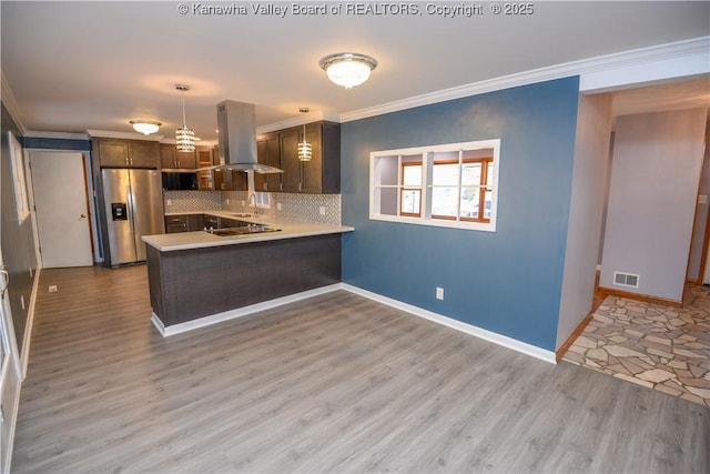 kitchen featuring stainless steel fridge, hanging light fixtures, island exhaust hood, kitchen peninsula, and light wood-type flooring