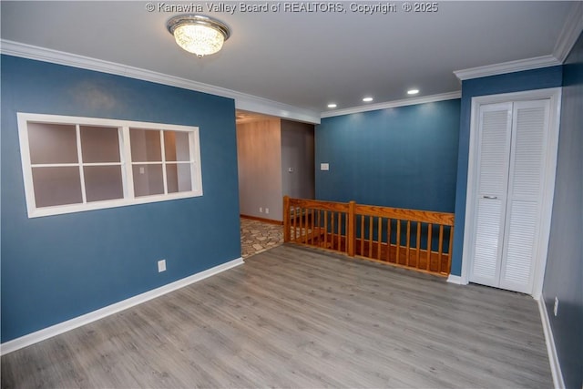 empty room featuring crown molding and light hardwood / wood-style flooring