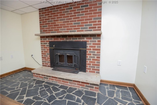 details with a paneled ceiling and a wood stove