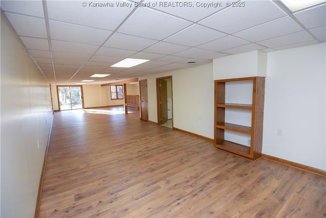 spare room featuring hardwood / wood-style floors and a drop ceiling