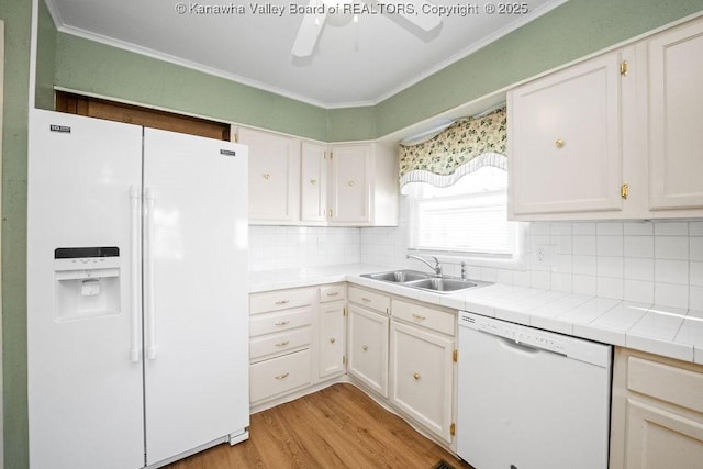 kitchen with white cabinetry, sink, light hardwood / wood-style floors, crown molding, and white appliances