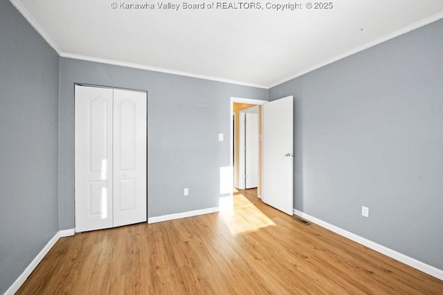 unfurnished bedroom with ornamental molding, light hardwood / wood-style floors, and a closet