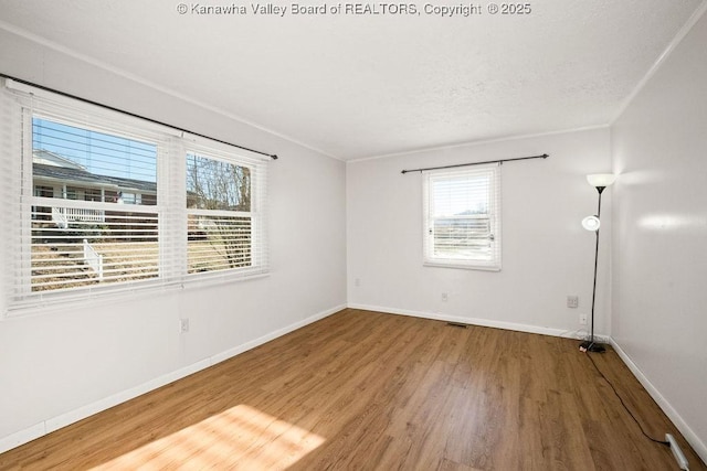 unfurnished room featuring hardwood / wood-style flooring and a wealth of natural light