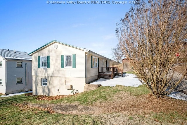 view of side of home featuring a lawn and a deck