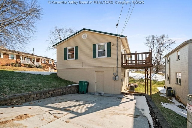 back of house with a wooden deck, a patio, cooling unit, and a lawn