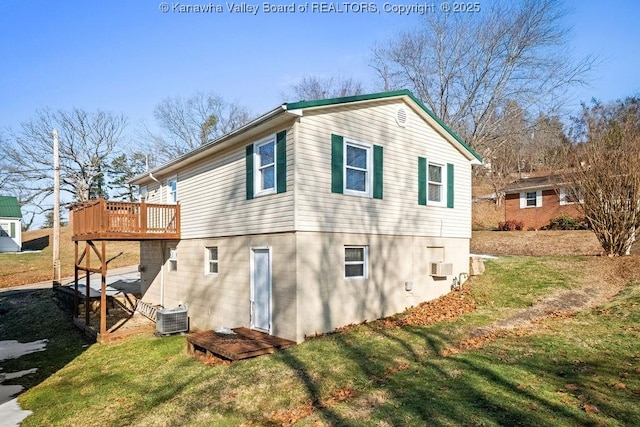 view of side of property featuring a wooden deck, central AC, and a lawn