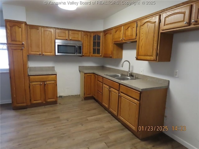 kitchen with sink and light hardwood / wood-style flooring