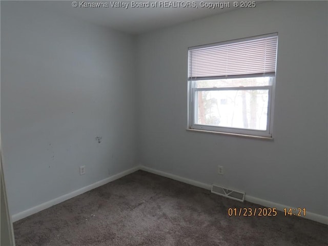 spare room with dark carpet