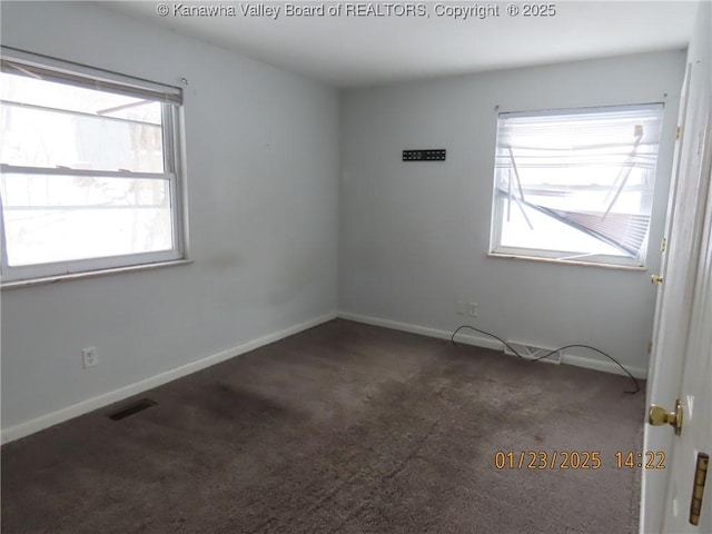 unfurnished room with dark colored carpet