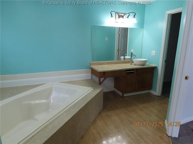 bathroom featuring vanity, hardwood / wood-style floors, and tiled bath