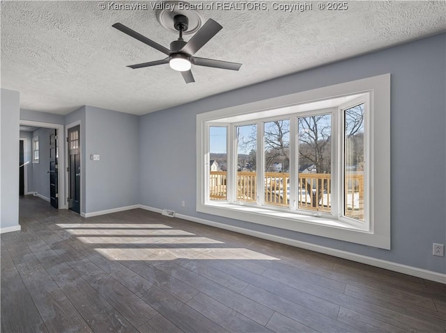 empty room with ceiling fan, a textured ceiling, and dark hardwood / wood-style flooring