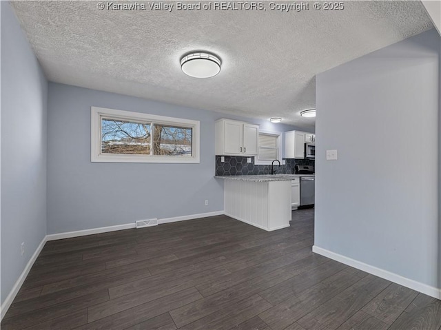 kitchen featuring dark wood-type flooring, sink, white cabinets, and decorative backsplash