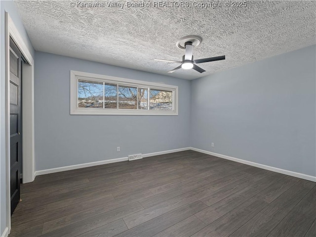 spare room with dark hardwood / wood-style floors, a textured ceiling, and ceiling fan