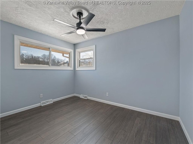 spare room with dark hardwood / wood-style floors, a textured ceiling, and ceiling fan