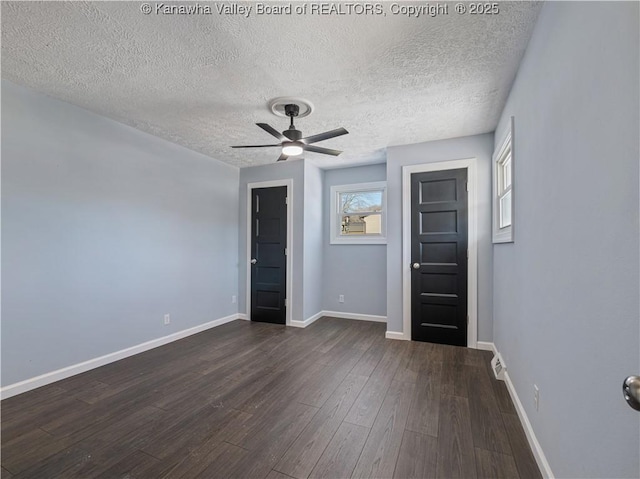 spare room with dark wood-type flooring, ceiling fan, and a textured ceiling