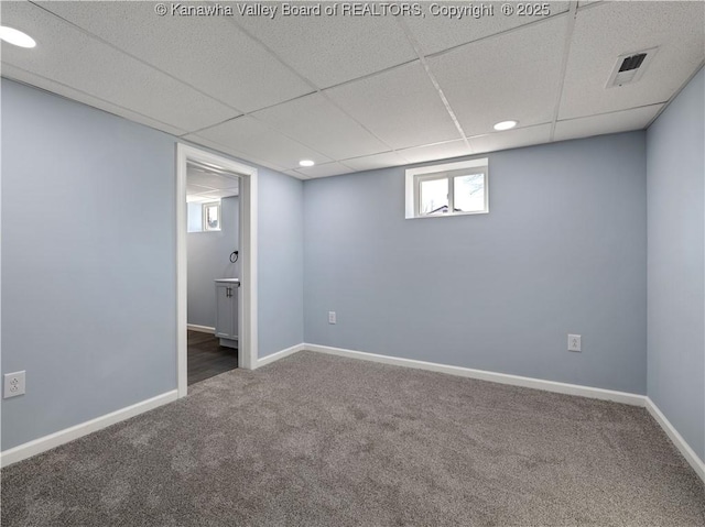 basement featuring a drop ceiling and carpet