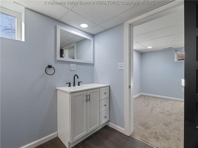 bathroom with vanity, hardwood / wood-style flooring, and a paneled ceiling