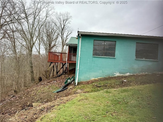 view of property exterior with a wooden deck and a lawn