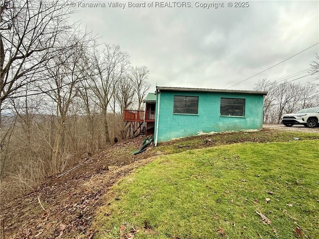 view of property exterior featuring a wooden deck and a yard