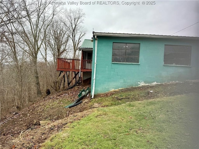 view of property exterior with a wooden deck and a yard