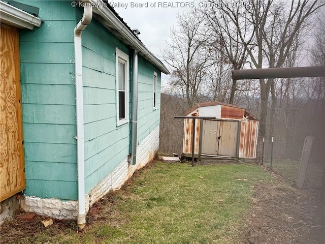 view of side of home featuring a lawn and a storage shed