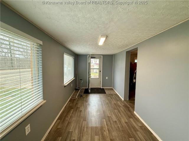 doorway to outside featuring dark hardwood / wood-style flooring and a textured ceiling