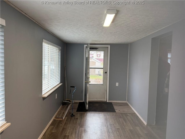 entryway featuring dark wood-type flooring and a textured ceiling