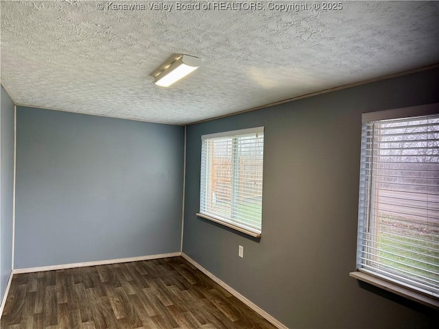 spare room with dark hardwood / wood-style floors and a textured ceiling