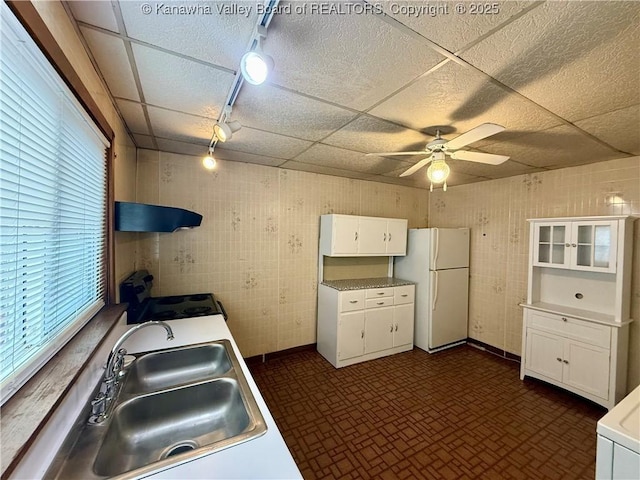 kitchen featuring sink, electric range, white refrigerator, white cabinets, and a drop ceiling